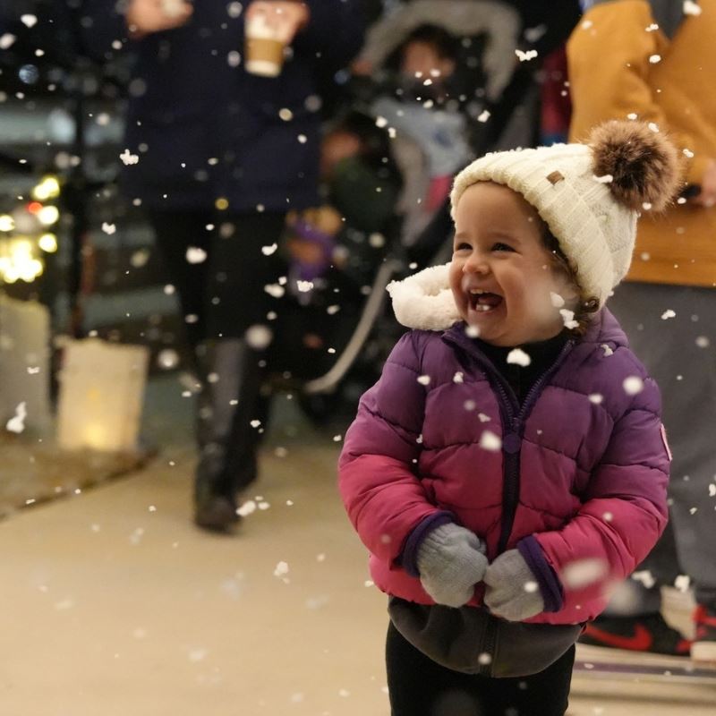 Little girl smiles big while walking through Merry Municipal light show